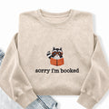 Embroidered Sorry I'm Booked Reading Raccoon Washed Crewneck Sweatshirt